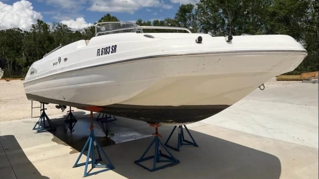 A white Hurricane SS231 CC speed boat resting on boat jacks on a dock.