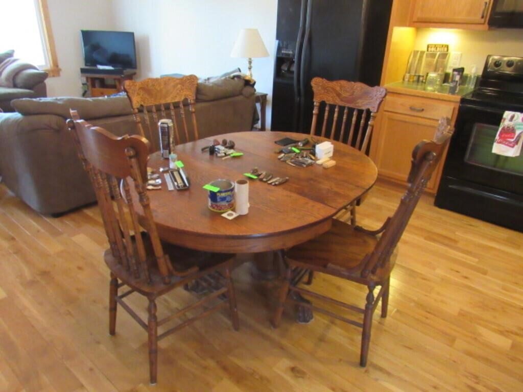 An oak dining room set with an oval table and four chairs.